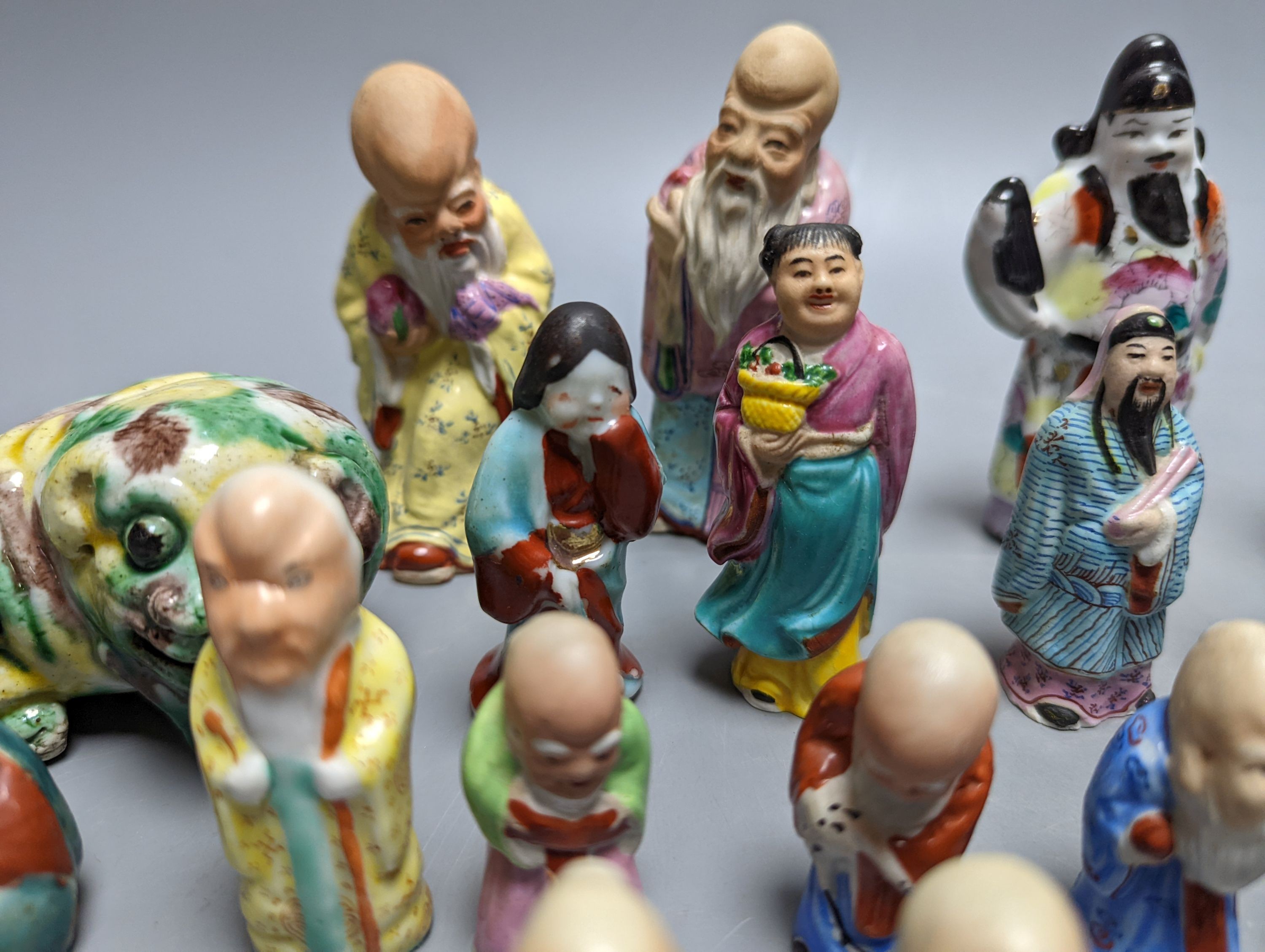 A collection of Chinese enamelled porcelain miniature figurines, including a 19th century Chinese sancai enamelled biscuit figure of a beast, 9cm